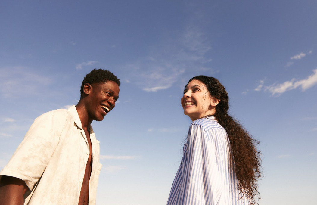 Pareja de viaje a contraluz sobre cielo azul